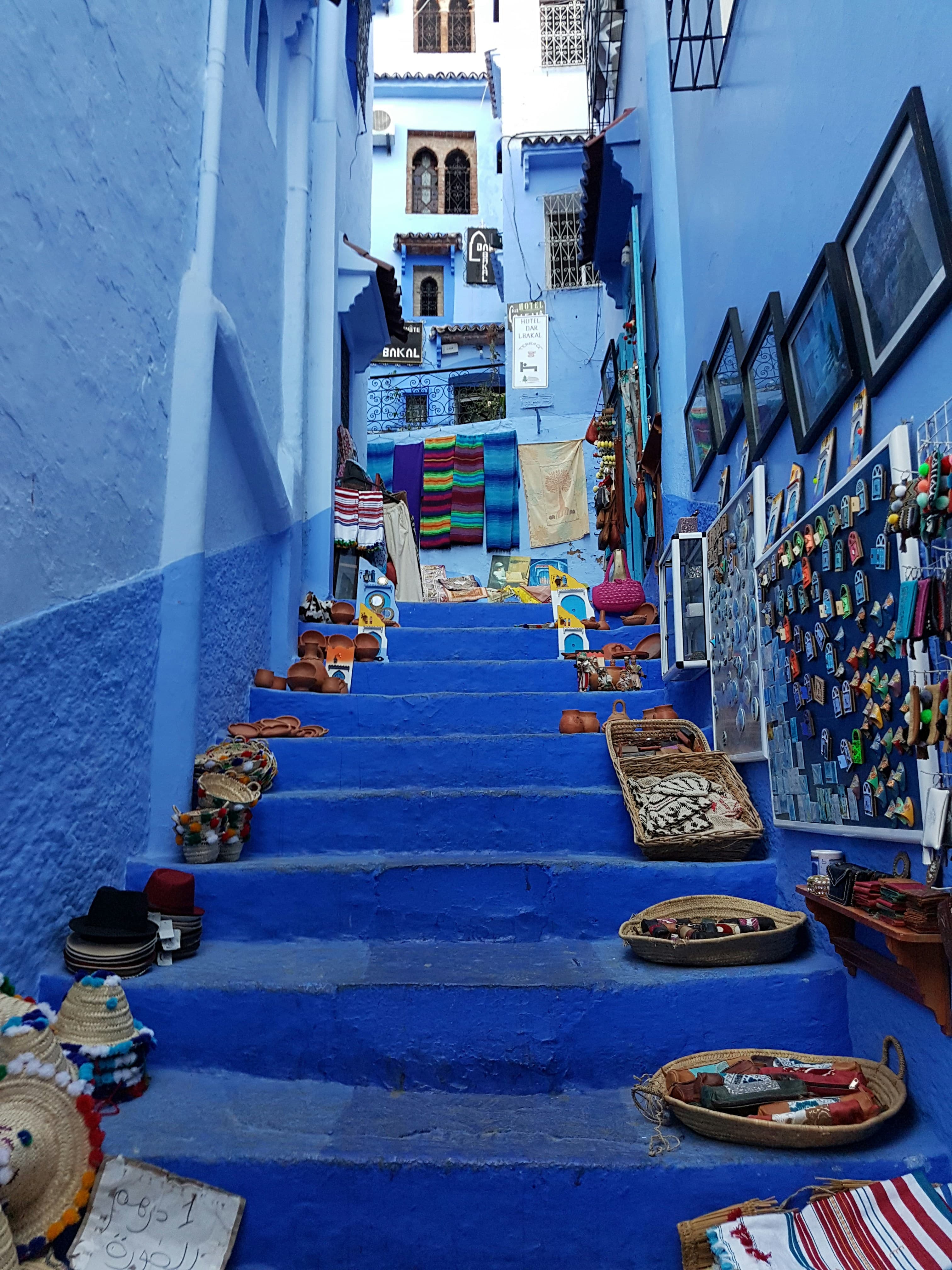 Des escaliers bleus de Chefchaouen bordés de paniers tressés et de textiles colorés