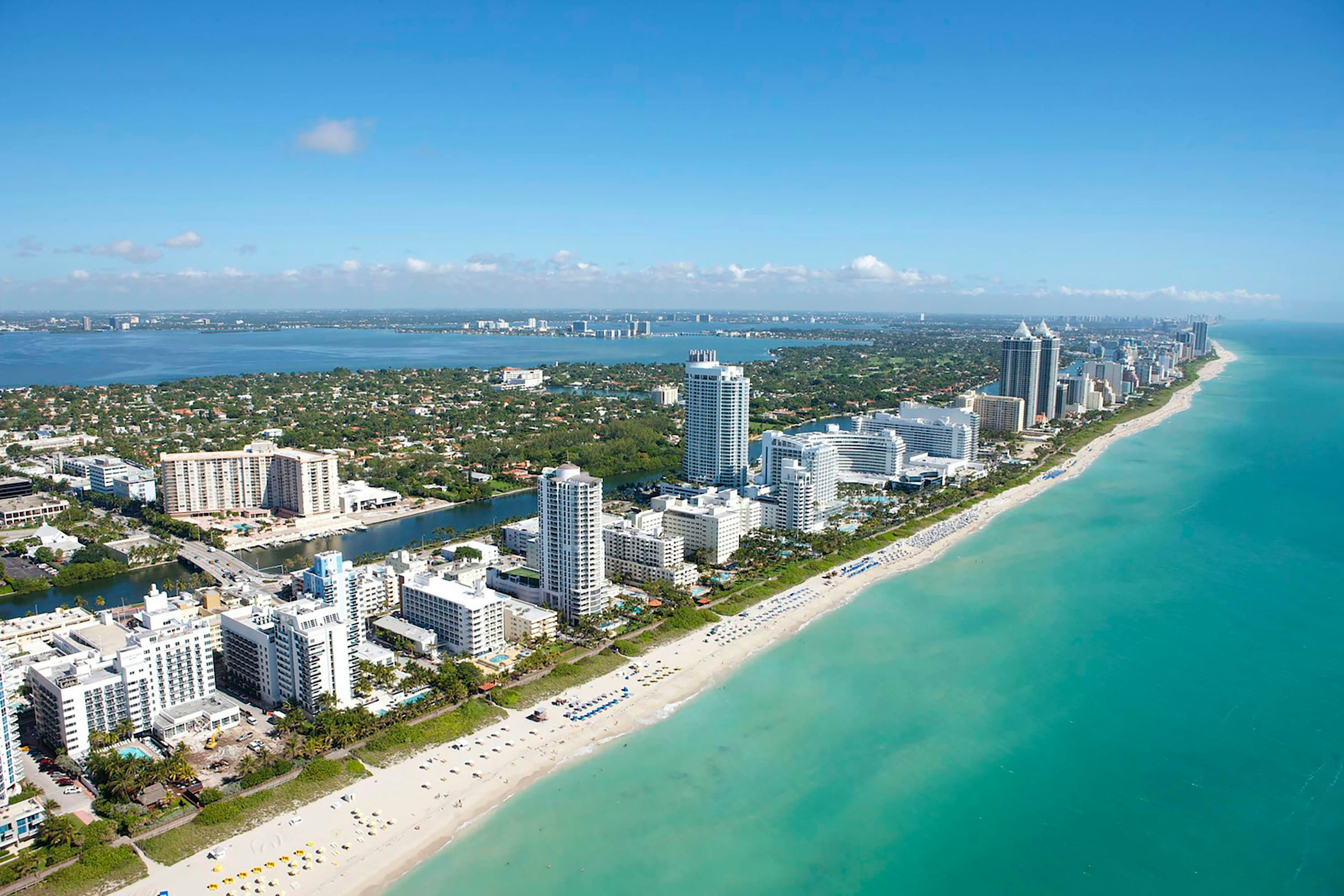 Aerial view of Miami Beach high-rises along a white-sand beach and turquoise ocean