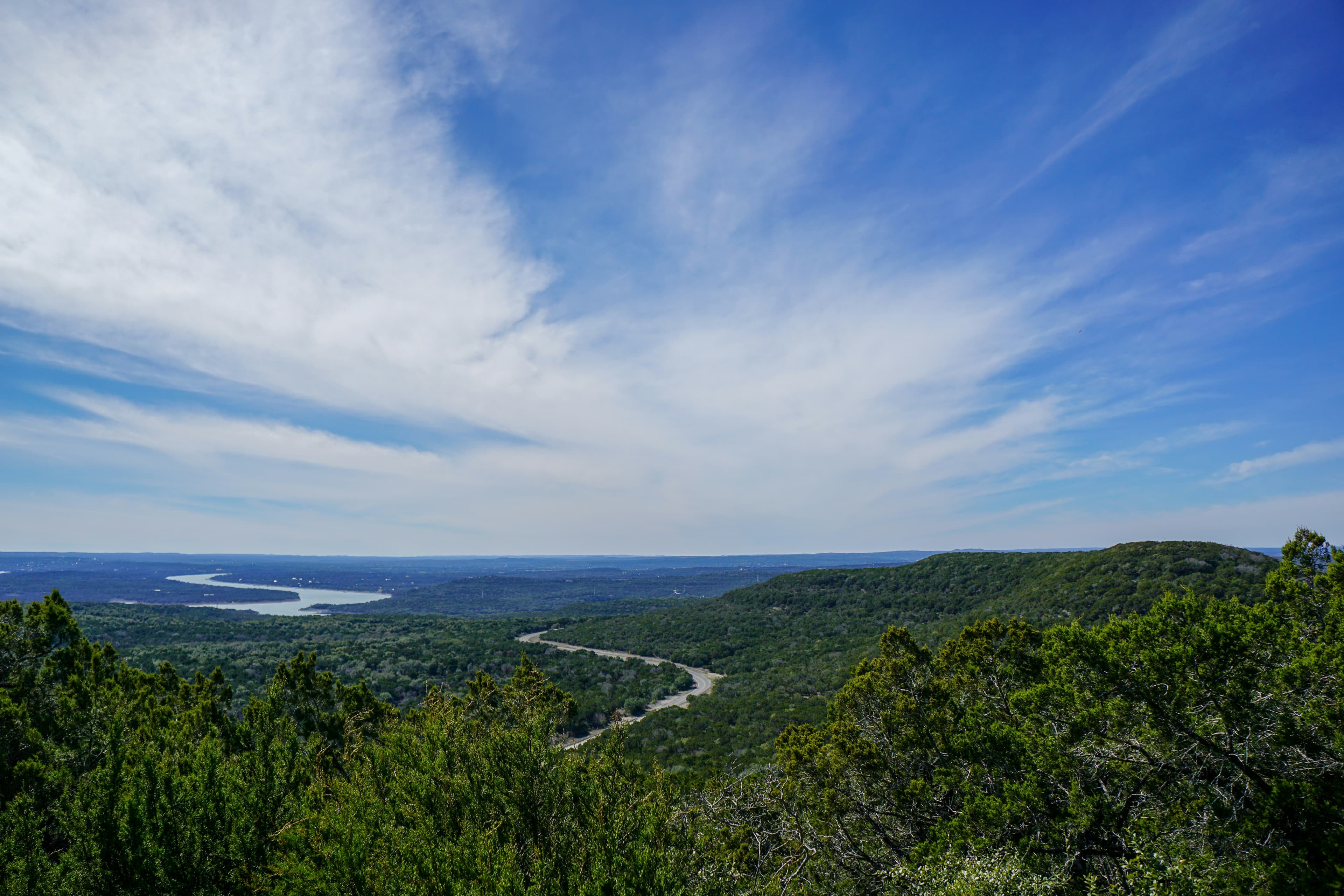 Green fields beside a river under a blue sky in the Texas Hill Country