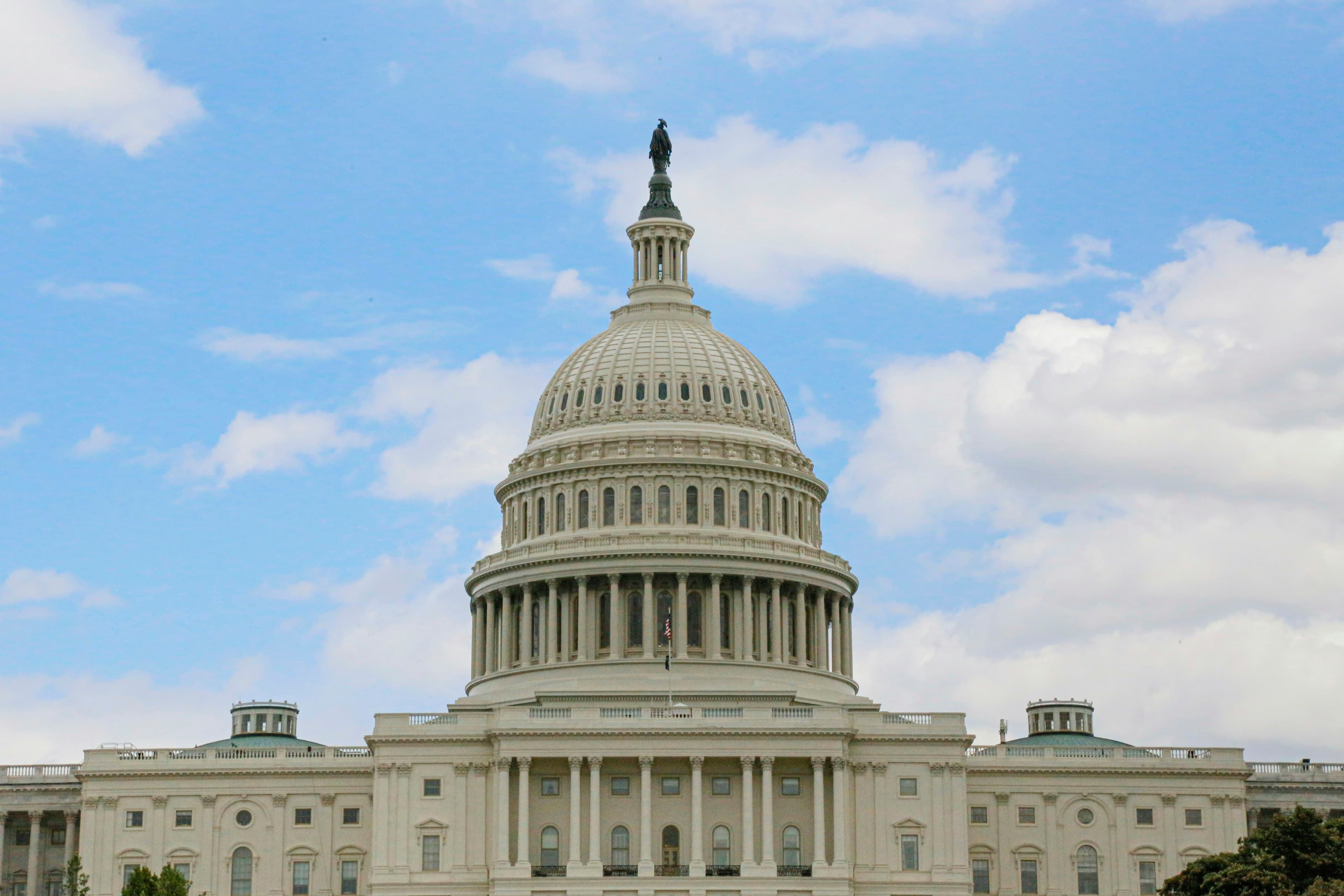 United States Capitol dome under a blue sky with white clouds in Washington, DC
