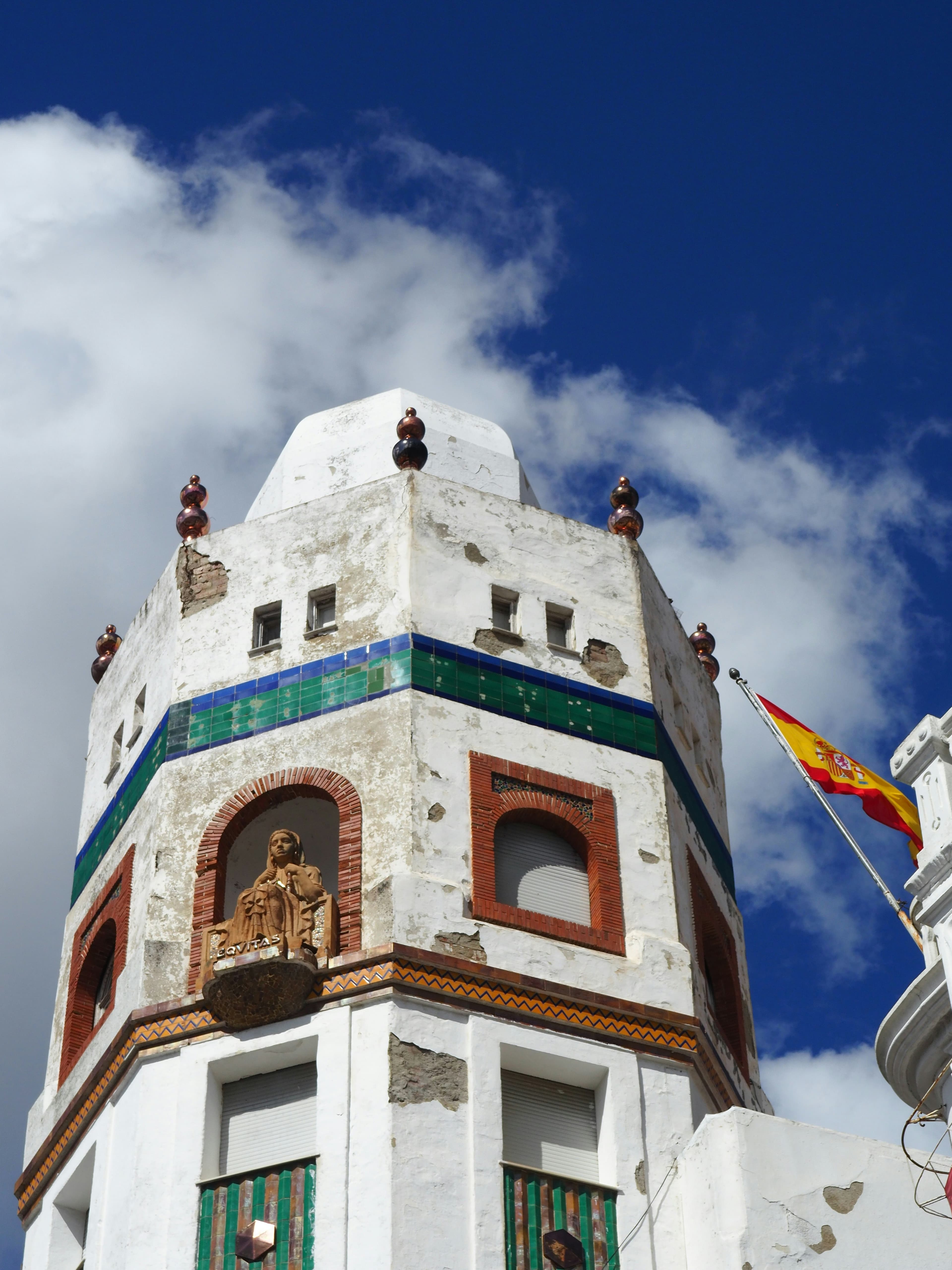 Un grand bâtiment blanc surmonté d'une horloge, dans le centre de Tétouan