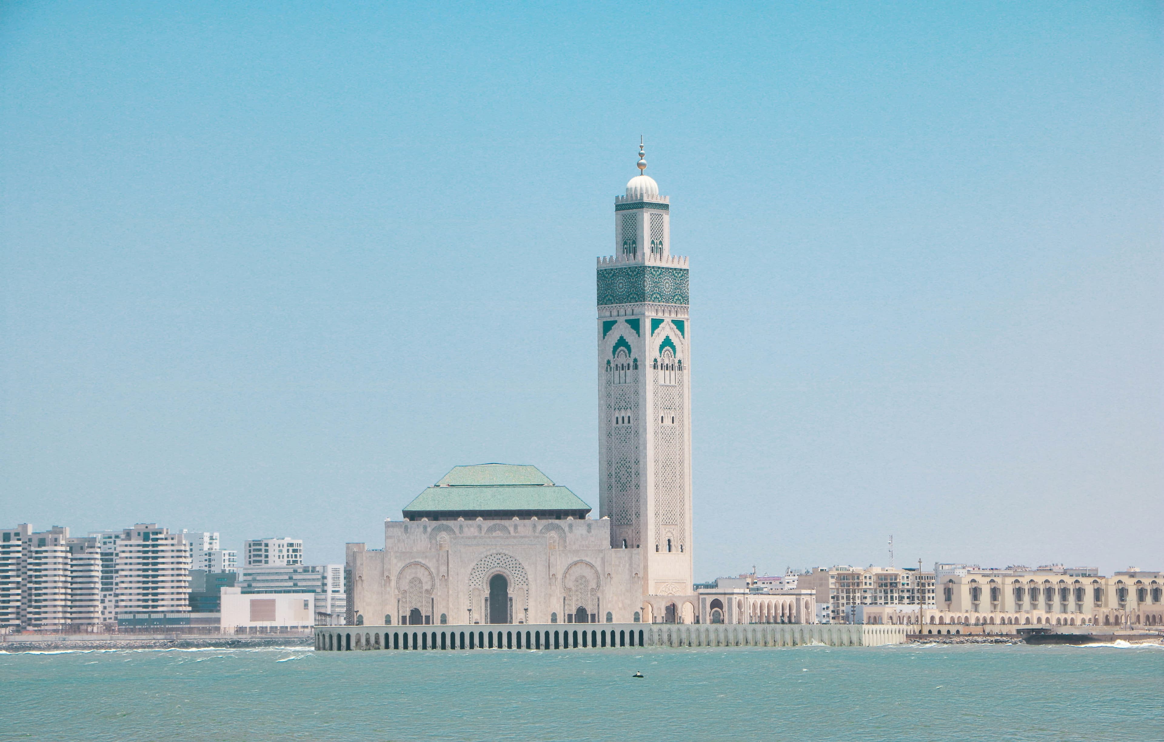 Un grand bâtiment blanc au toit vert au bord de l'eau, à Casablanca