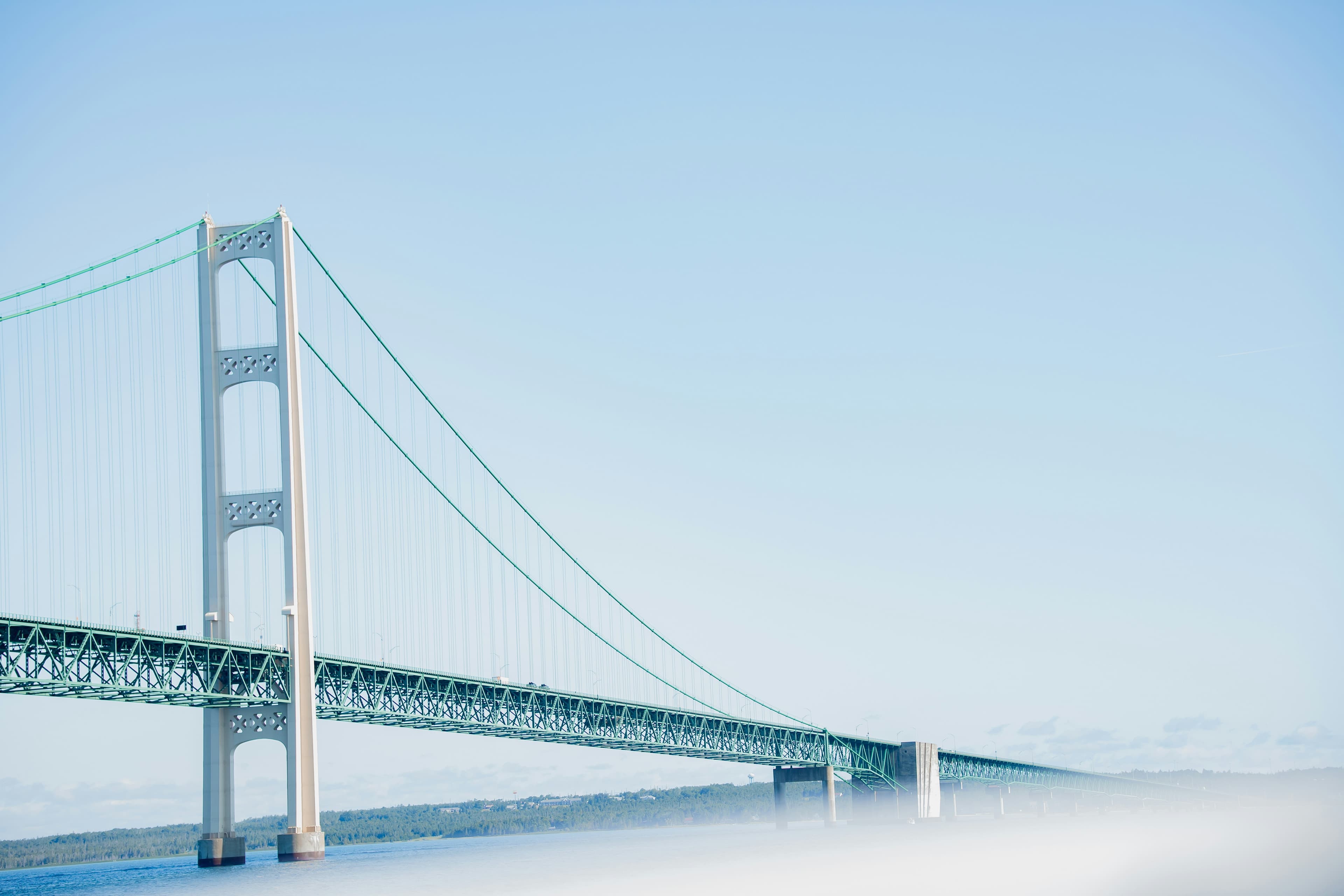 The Mackinac Bridge spanning the Straits of Mackinac in Michigan, with low fog over the water