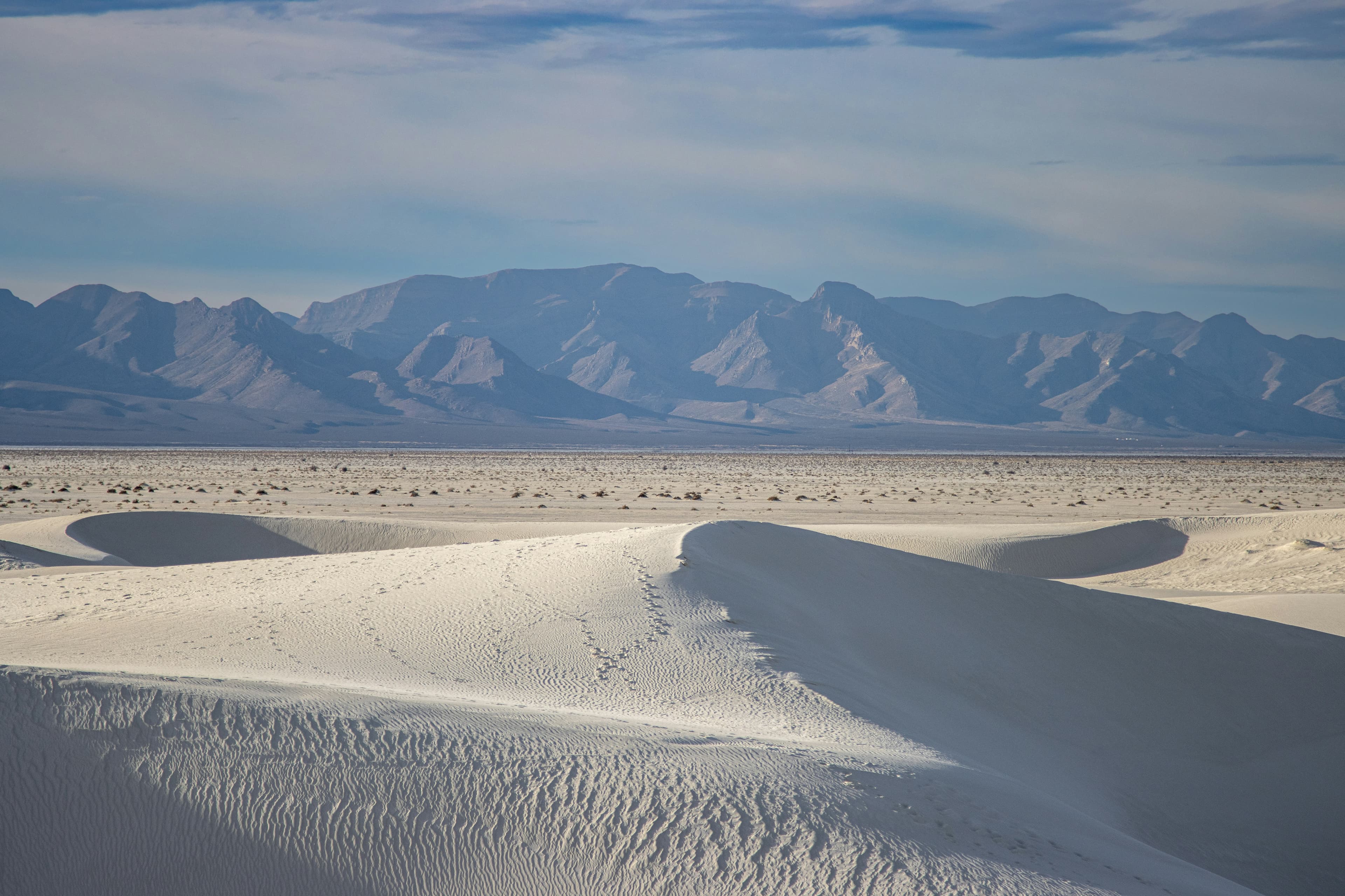 White gypsum dunes with mountains on the horizon in White Sands National Park, New Mexico