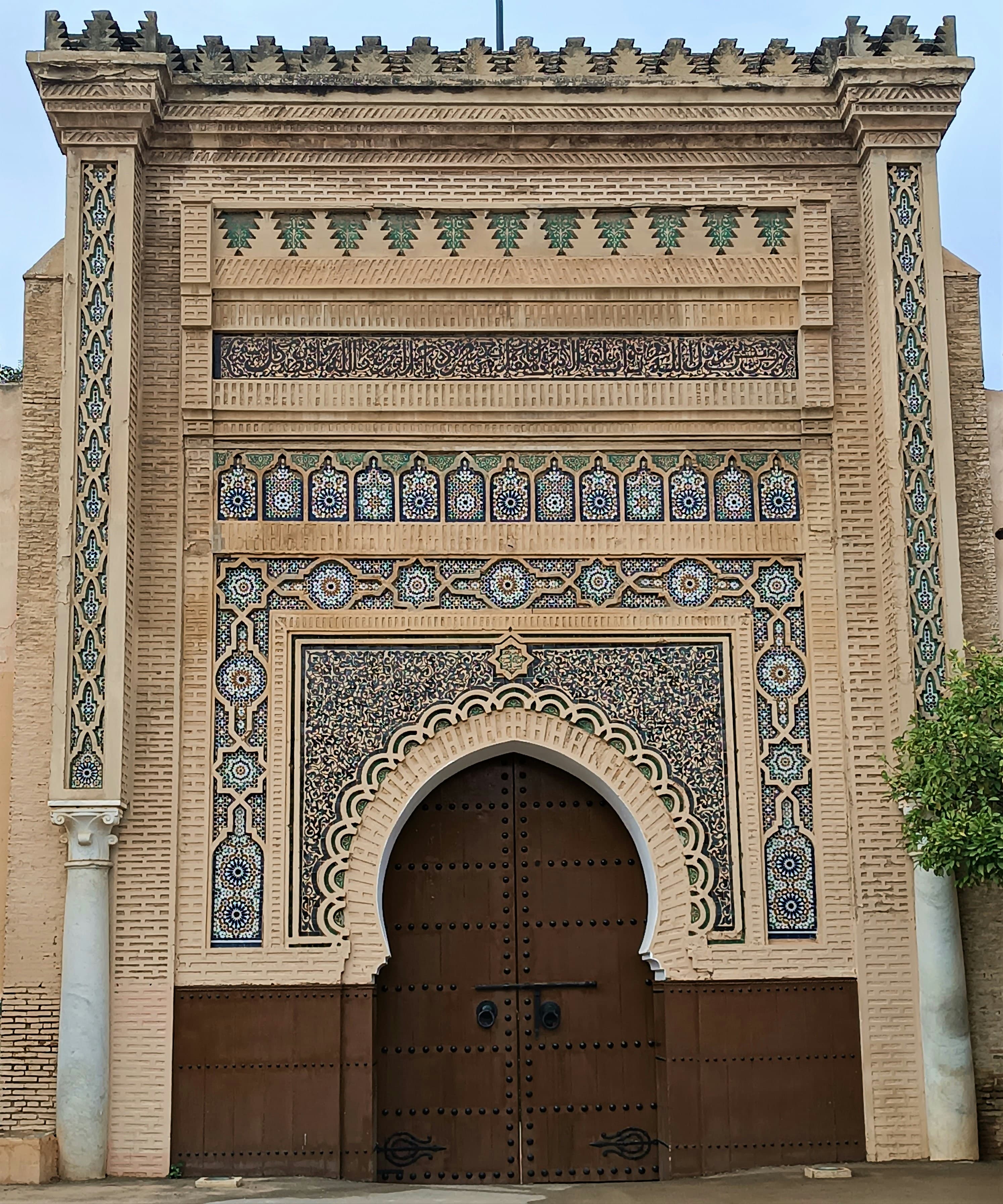 Une grande porte monumentale en bois dans les remparts de Meknès